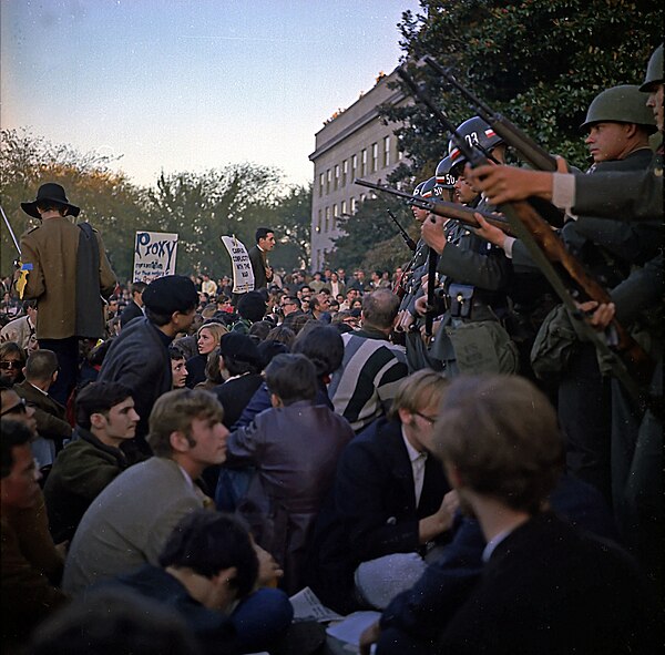Military police keep back Vietnam War protesters during their sit-in at the Pentagon's National Mall entrance on 21 October 1967