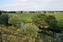 Photo d'un paysage de pairies avec une rivière au premier plan