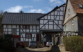 English: Half-timbered building in Wartenberg, Angersbach, Hainigweg 14 (behind), Hesse, Germany.