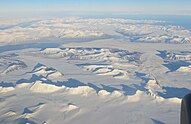 An aerial photograph of a snowy mountain range