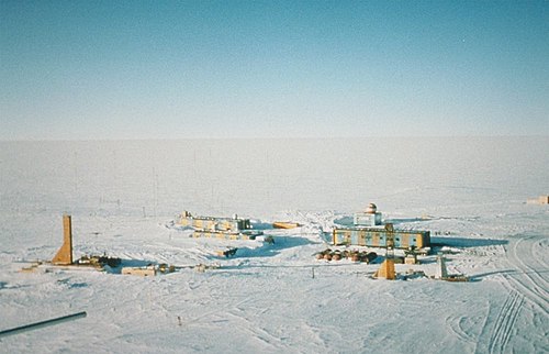 Panoramic photo of Vostok Station showing the layout of the camp. The striped building on the left is the power station while the striped building on the right is where researchers sleep and take meals. The building in the background with the red- and white-striped ball on top is the meteorology building. Caves were dug into the ice sheet for storage, keeping cores at an ideal −55 °C (−67 °F) year-round. (Credit: Todd Sowers LDEO, Columbia University, Palisades, New York.)