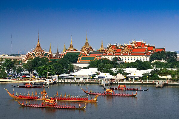 Royal Barge Ananta Nakkharat (2nd-nearest), flanked by escort barges Phali Rang Thawip (nearest) and Sukhrip Khrong Mueang (3rd), as the procession pa