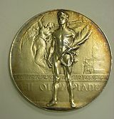 One of the 154 (identical) gold medals awarded at the Games of the VII Olympiad 2000-158-19 Medal, Olympics, 1920, Antwerp, Gold, Obverse (7268561188) (cropped).jpg