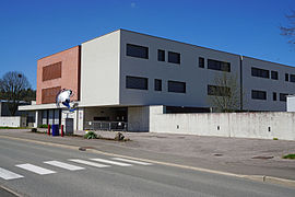 Grand bâtiment cubique blanc et brique.