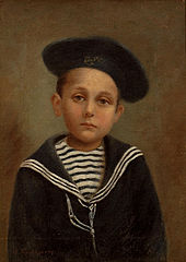 photo d'un enfant habillé en marinière et portant un bonnet marin à pompon.