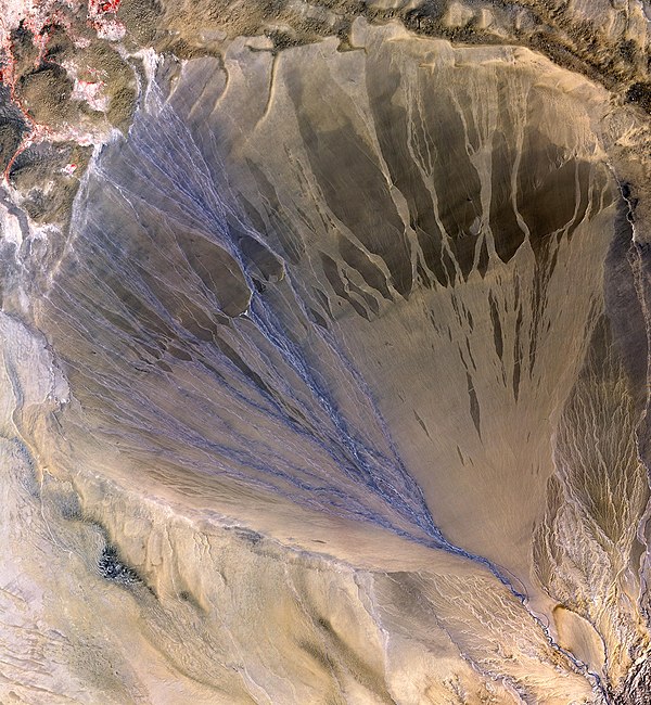 The Molcha (Moleqie) River forms a vast alluvial fan at the southern border of the Taklamakan Desert, as it leaves the Altyn-Tagh mountains and enters