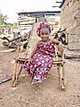 Biiga zomba gɛlé.The Child is seating in the chair