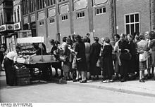 [2] Frauen stehen 1946 in Berlin Schlange vor einem Gemüsestand