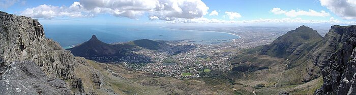 Panorama de la cima de la Montaña de la Mesa, de izquierda a la derecha son visibles la Cabeza de León, Signal Hill, Robben Island, el centro de Ciudad del Cabo, Bahía de la Mesa, y el Pico del Diablo.