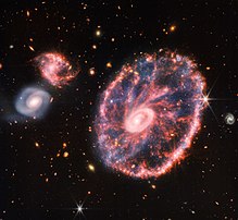 La galaxie de la Roue de chariot, galaxie lenticulaire à anneau située dans la constellation du Sculpteur, photographiée par la caméra NIRCam du télescope spatial James-Webb. (définition réelle 4 685 × 4 312)
