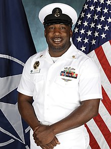 Chief Petty Officer Alston taking a photo in celebration of leading the warfighters. Chief Alston at NATO.jpg