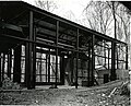 Sections of wall 12x16 feet insize were built within rigid portable steel frames (left). After drying, each section was moved via crane to the oil-burning furnace, which formed one wall (far wall in image). After exposure to heat, the sections were moved into the central place and sprayed with a fire hose.