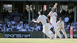 An Australian fielder runs to take a catch In the air.jpg