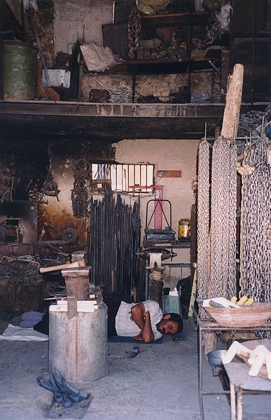 File:Iran - Ispahan - Dans une rue, échoppe sieste forgeron, établi, métaux - Iranian shop, smith having a nap (9262415668).jpg