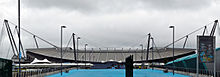 Panorama of north end of stadium as viewed from southern approach along Joe Mercer Way Joe Mercer Way - Etihad.jpg