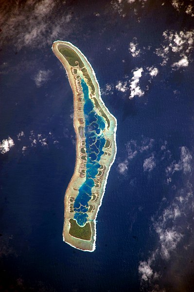 Caroline Island, visible in an astronaut photograph taken in 2009. The inner lagoon appears a lighter blue than the deeper ocean.
