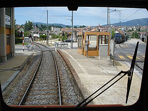 Station platform with a shelter and a railway crossing