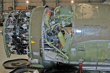 A P-47 engine with the cowling removed. Uncompressed air enters through an intake under the engine and is carried to the turbosupercharger behind the pilot via the silver duct at the bottom. The olive-green pipe returns the compressed air to the engine[4]