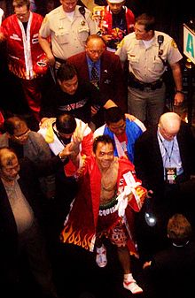 Pacquiao leaving the ring after his first fight against Erik Morales, 2005 Pacquiao, Bloody but happy.jpg