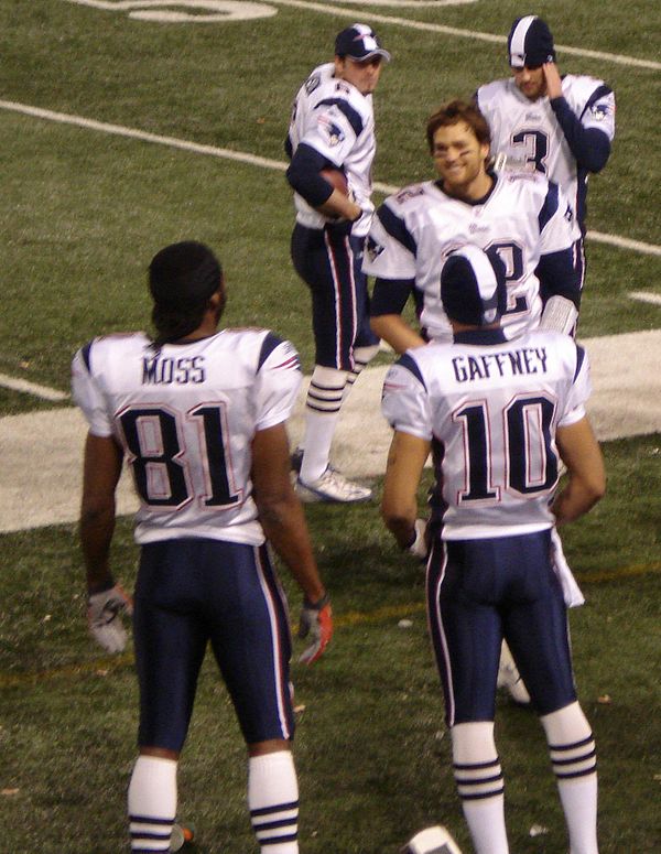 Tom Brady on the sideline with teammates Randy Moss and Jabar Gaffney, after throwing for his record-breaking 50th passing touchdown of the season. Be