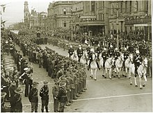 Una fotografía en blanco y negro de una procesión militar.