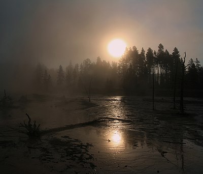 Korona Matahari tidak beraturan di atas uap dari mata air panas dan kabut pagi di Taman Nasional Yellowstone.