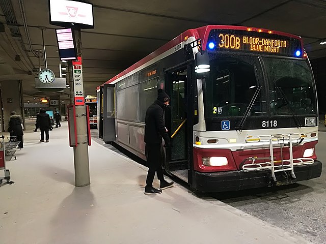 A passenger boards an Orion VII bus owned and operated by the TTC in Toronto Pearson International Airport. The TTC operates the third-largest fleet o