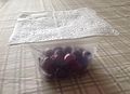 Tupperware container of cherries with a makeshift napkin lid.jpg