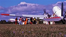 Two C-47s - one boarding skydivers, while another taxis by, 1977 Two DC-3s - one loading, one taxiing.jpg