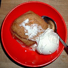 Boulette de pommes servies avec une boule de glace à la vanille.