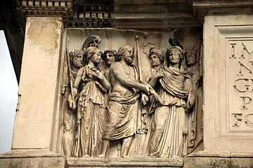 Sur l'attique, à gauche de l'inscription : les dieux de l'Olympe attendent Trajan.