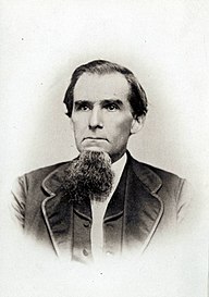 mustavalkoinen valokuva miehestä, jolla on vaalea iho, tummat hiukset ja parta