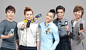 Big Bang posing for the camera while holding cellphones