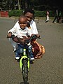 Burundian woman on the his child's bike.jpg