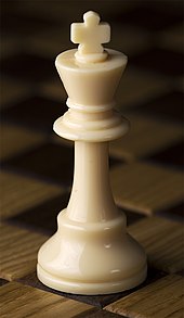 As peças de xadrez no tabuleiro são empilhadas e o rei está no topo contra o  céu dramático ganhe a qualquer custo