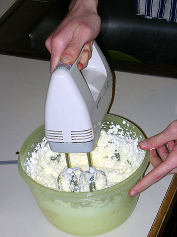 Churning cream into butter using a hand-held mixer.