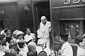 Crowd greets Gandhi as he exits a train at a station.jpg