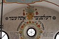 Detail malého okna na stěně zadní synagogy, okolo jsou rekonstruovány nápisy a malby.
