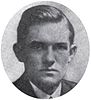 Round portrait of a stern-faced young man dressed in a suit.