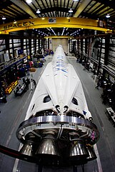 Falcon 9 ahead of CRS-3 with landing legs visible Falcon 9 with CRS-3 Dragon in SLC-40 hangar (16856371855).jpg