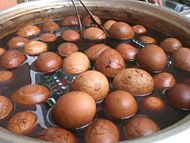 A batch of tea eggs with shell still on soaking in a brew of spices and tea, an example of edible eggs