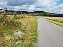 Vergitterter Zugang zur Grabenponorhöhle am Klusensteiner Weg.