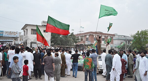 A supporter of PMLN in NA 49 Islamabad, in Model Town Hummak, on the roof of a car rising his party flag and announcing the triumph of his party in th