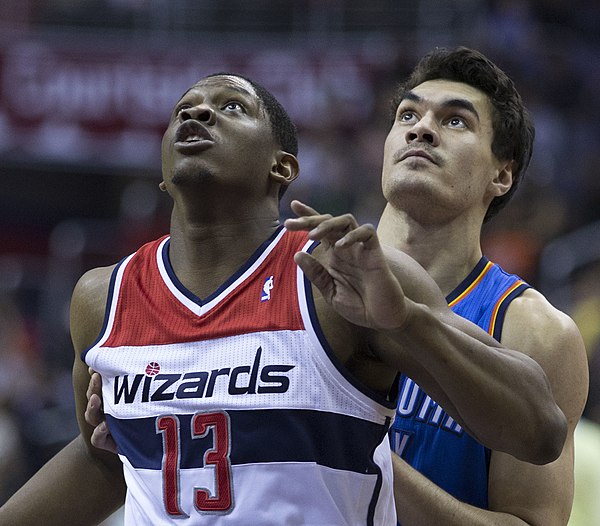 Adams (right) with the Thunder in February 2014, contesting with Kevin Séraphin of the Washington Wizards