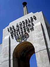 The peristyle and Olympic Torch of the Coliseum LA Coliseum gate.jpg