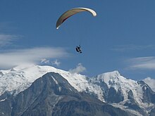 Parapentista en frente de la cumbre del Mont Blanc.