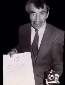Mexican Artist Pedro Linares López, father of Alebrijes, wearing a suit (for the first time in his life) holds and shows a medal that symbolize the National Prize for Science and Arts (Mexico) 1990