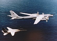 An F-14A Tomcat intercepting a Soviet Tupolev Tu-95RTs Bear D maritime recon aircraft over the Pacific Ocean in 1984 Tomcat escorts Bear.jpg