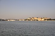 Die Stadtpaläste und der Seepalast in Udaipur am Abend vom Jag Mandir im Picholasee aus gesehen.