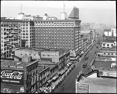 Looking north on Main from 6th c. 1917. Tall building is the Hotel Rosslyn main building. Visible: sign for Isaias W. Hellman Bldg. at 124 W. 4th; Wesley Roberts, Higgins, San Fernando and Canadian buildings. Colyear's sign is site of Hotel Rosslyn Annex.